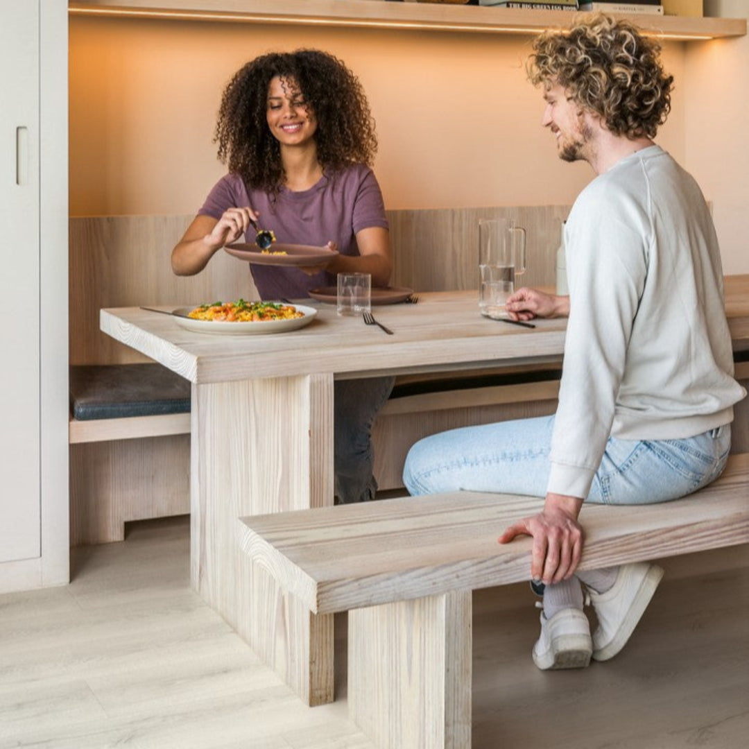 Senhora a servir comida num parto, homem sentado na sua frente